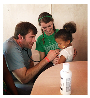 Dr. Ryan Rainer on a mission trip in Venezuela, holding stethoscope