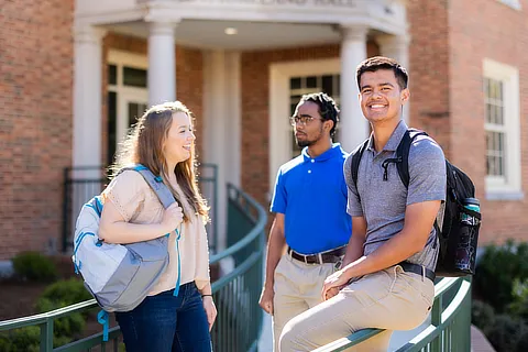 three students standing outside